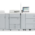 A large printer with many drawers and a computer.