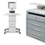 A computer and printer on top of a desk.
