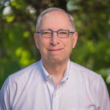 A man with glasses and a white shirt