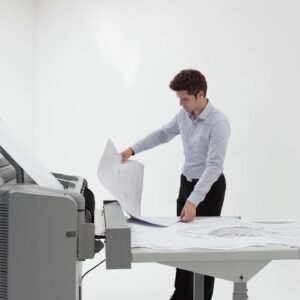 A man standing at the table with papers in front of him.