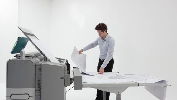 A man standing at the table with papers in front of him.