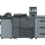A large printer with two drawers and three cabinets.