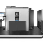 A large printer is shown in front of a wall.