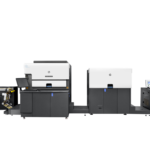 A large printer is shown in front of a black wall.