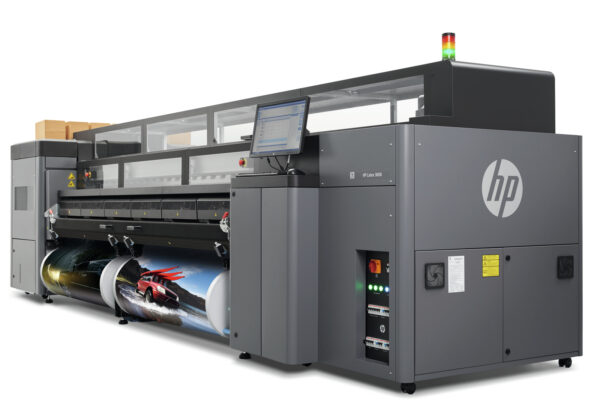 A large printer that is sitting in front of a wall.